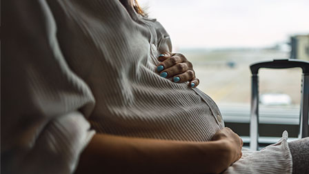Mujeres embarazadas Pregnant woman in a green shirt stroking her belly.