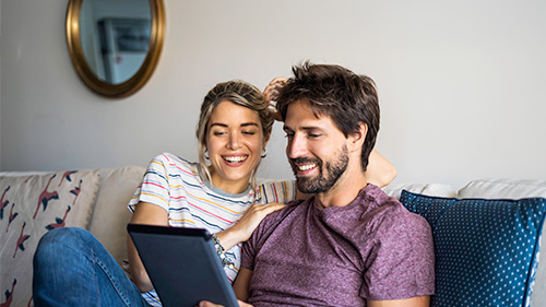 Prereserva Couple pre-booking flights on a tablet