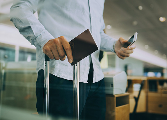Conexiones Otros Aeropuertos Mann mit Reisepass, Mobiltelefon und Handgepäck auf dem Flughafen
