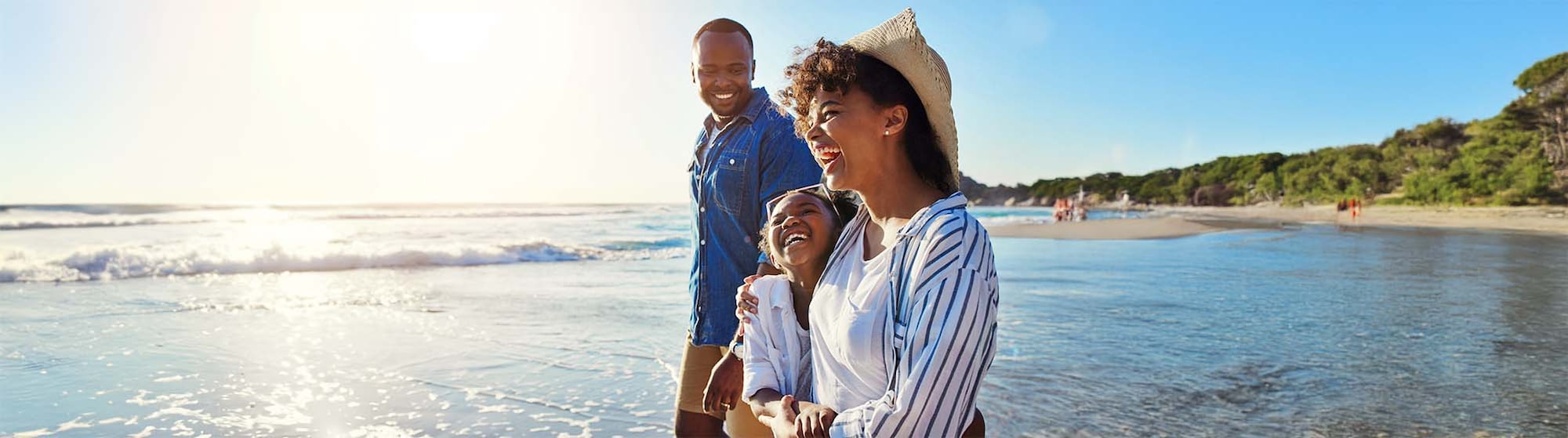 The image shows a family walking on the beach.